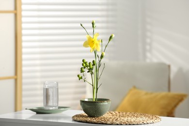 Photo of Stylish ikebana with beautiful yellow narcissus flower carrying cozy atmosphere at home