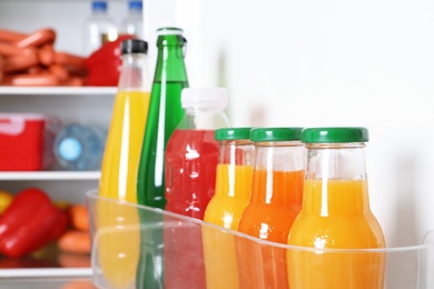 Bottles of beverages on refrigerator door shelf, closeup