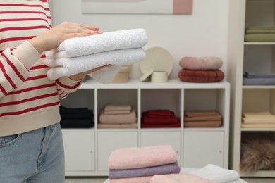Photo of Customer holding towels in home textiles store, closeup. Space for text