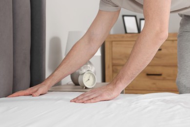 Photo of Man changing bed linens at home, closeup