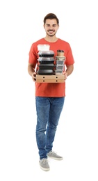 Young courier with pizza boxes, containers and drinks on white background. Food delivery service