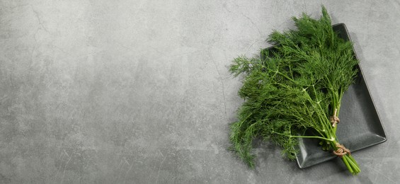 Image of Fresh dill on grey table, top view. Banner design with space for text