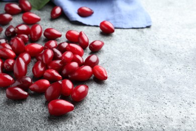 Photo of Pile of fresh ripe dogwood berries on grey table. Space for text