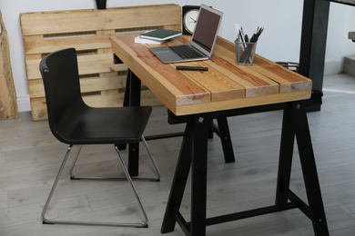 Photo of Comfortable workplace with office chair and wooden table