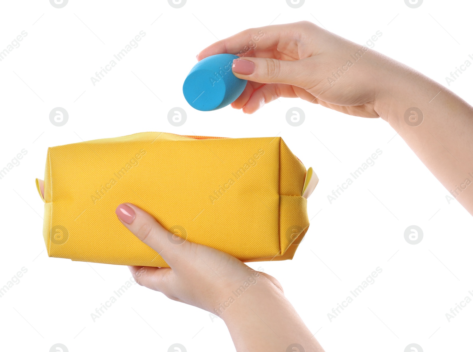 Photo of Woman putting makeup sponge into cosmetic bag on white background, closeup