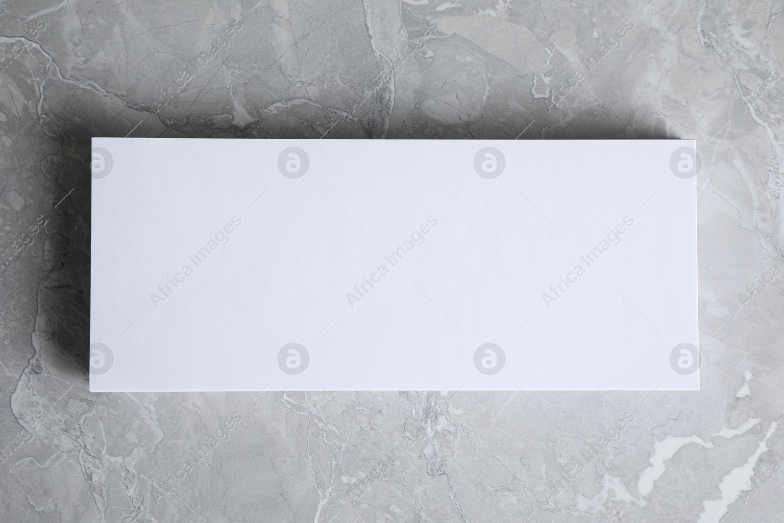 Photo of Blank palm card on light grey marble background, top view. Mock up for design