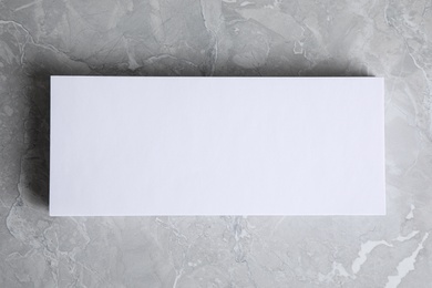 Photo of Blank palm card on light grey marble background, top view. Mock up for design