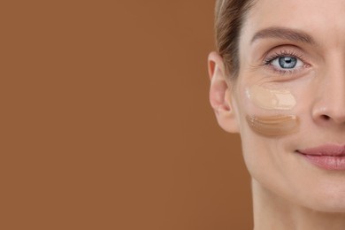 Woman with swatches of foundation on face against brown background, closeup. Space for text