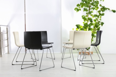 Photo of Empty chairs prepared for group psychotherapy session indoors