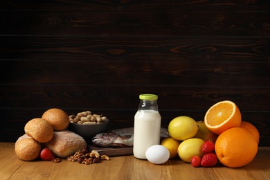 Photo of Allergenic food. Different fresh products on wooden table, space for text