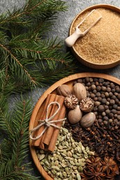 Photo of Different spices, nuts and fir branches on table, flat lay