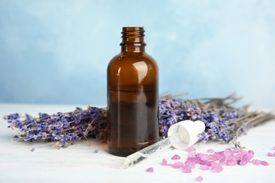 Photo of Bottle with aromatic lavender oil on wooden table