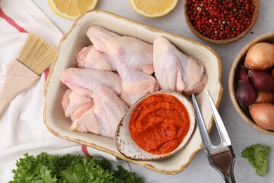 Photo of Flat lay composition with marinade, raw chicken and other products on light table