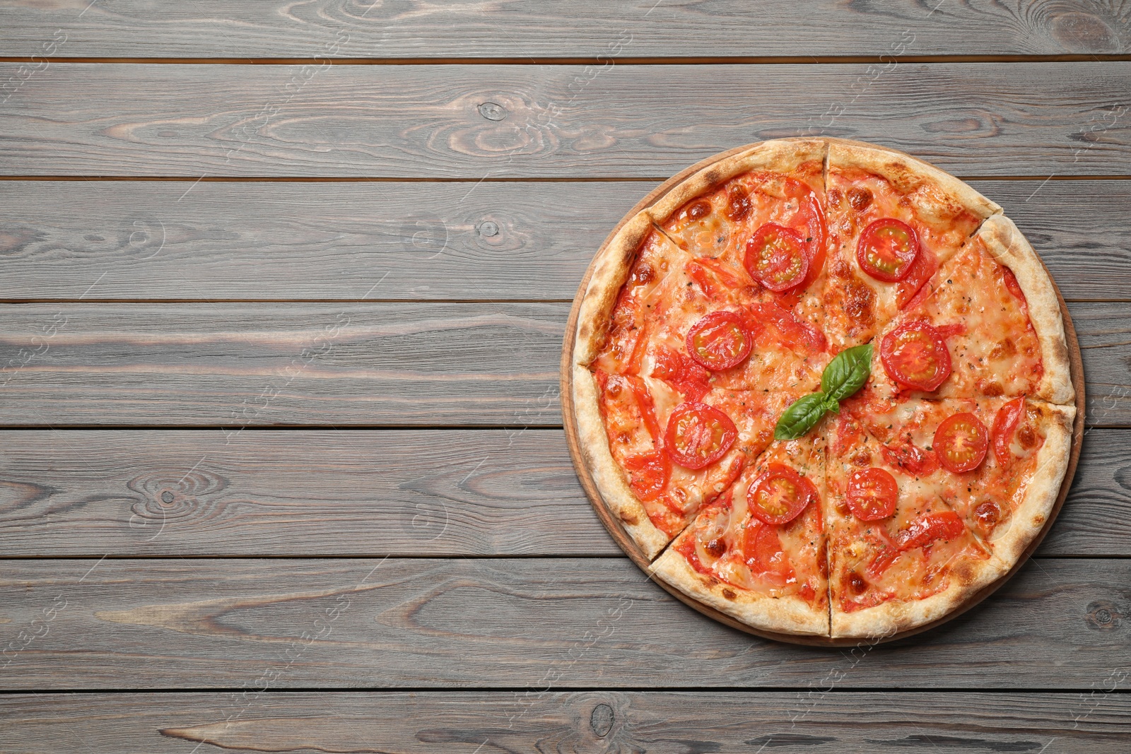 Photo of Delicious pizza Margherita on wooden table, top view. Space for text