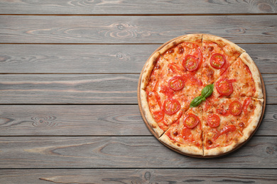 Photo of Delicious pizza Margherita on wooden table, top view. Space for text