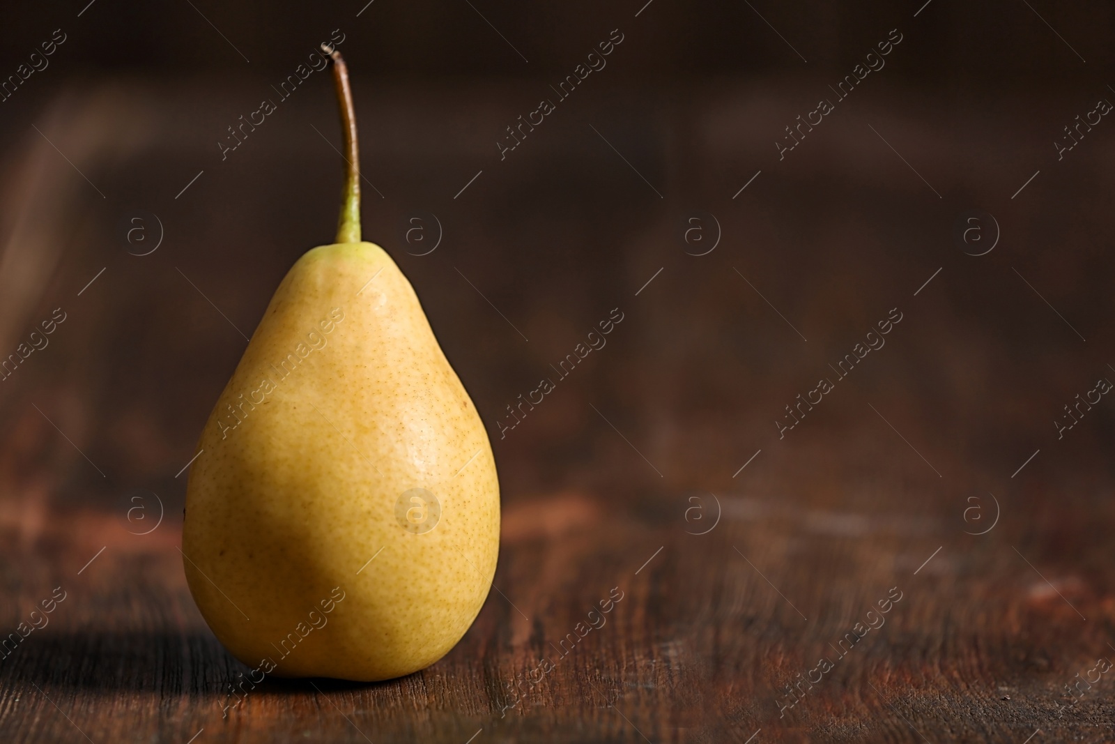 Photo of Ripe pear on wooden background. Space for text