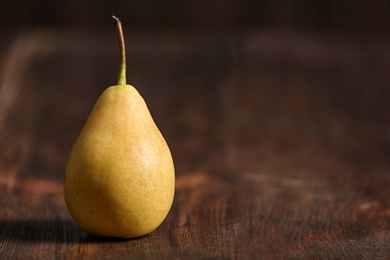 Photo of Ripe pear on wooden background. Space for text