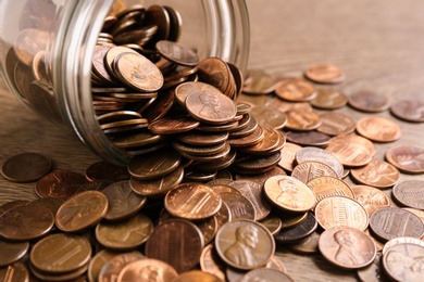 Glass jar with coins on table, closeup. Money saving concept