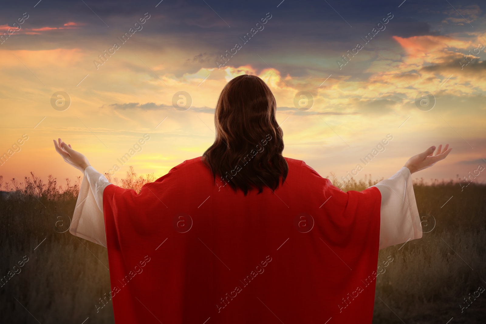 Image of Jesus Christ outdoors at sunset, back view