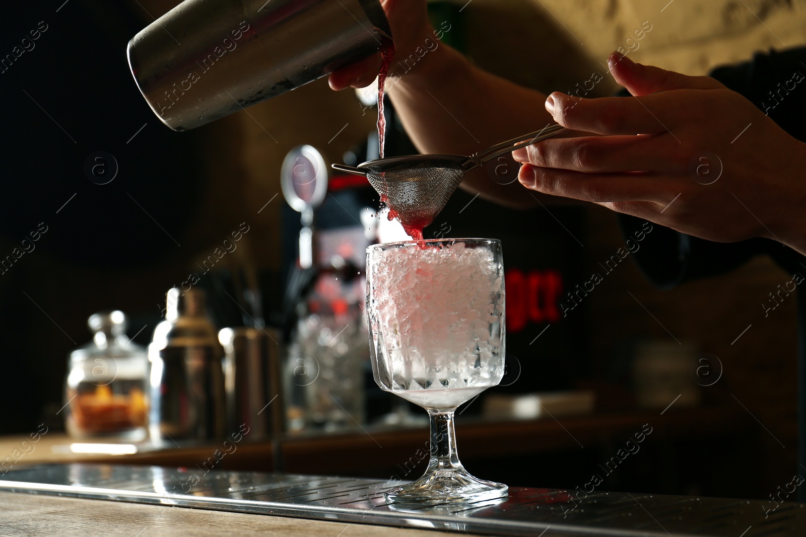 Photo of Bartender preparing fresh alcoholic cocktail at bar counter, closeup