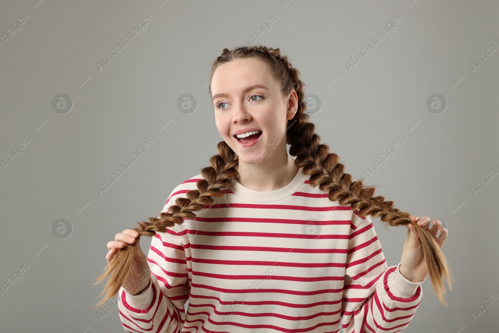 Photo of Woman with braided hair on grey background