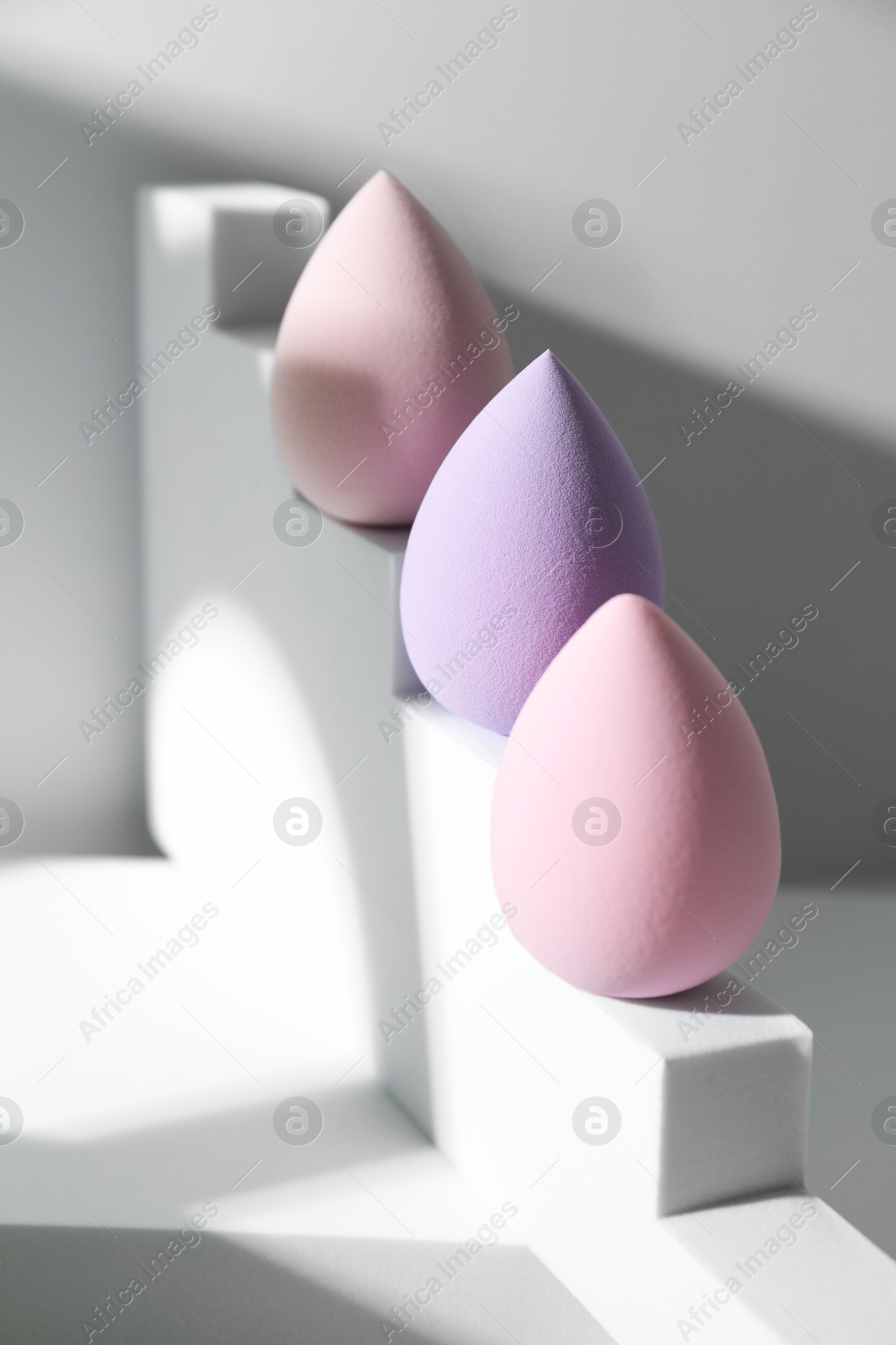 Photo of Stylish presentation of makeup sponges on white background