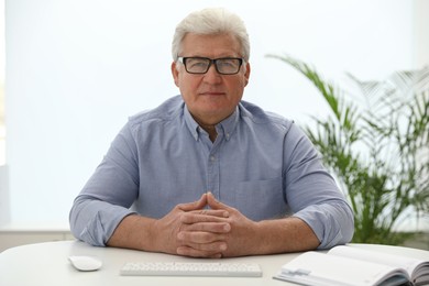 Mature man using video chat in office, view from web camera