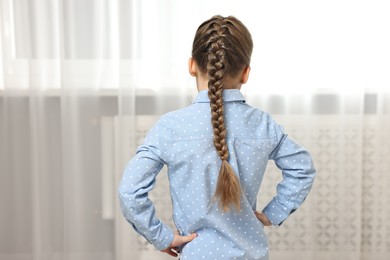 Photo of Little girl with braided hair indoors, back view