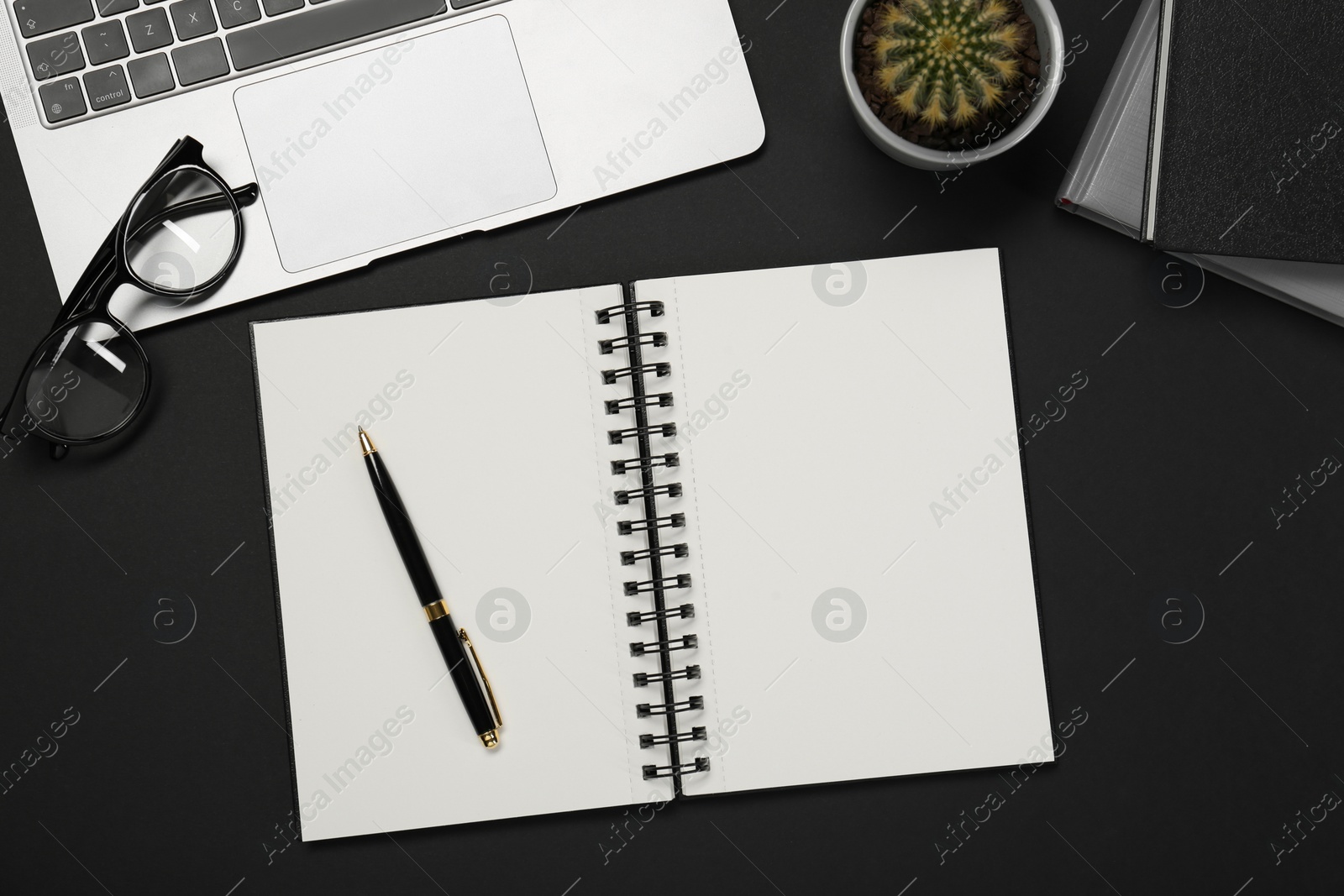 Photo of Flat lay composition with notebook and laptop on black table