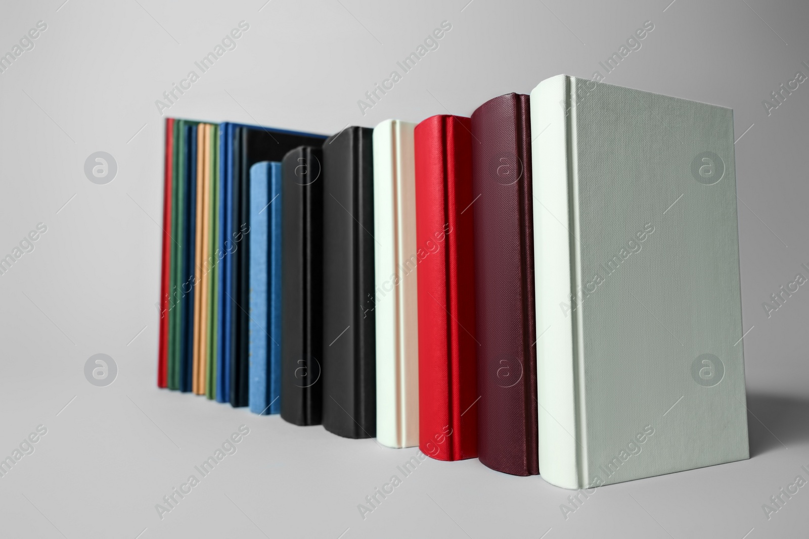 Photo of Many different hardcover books on light grey background