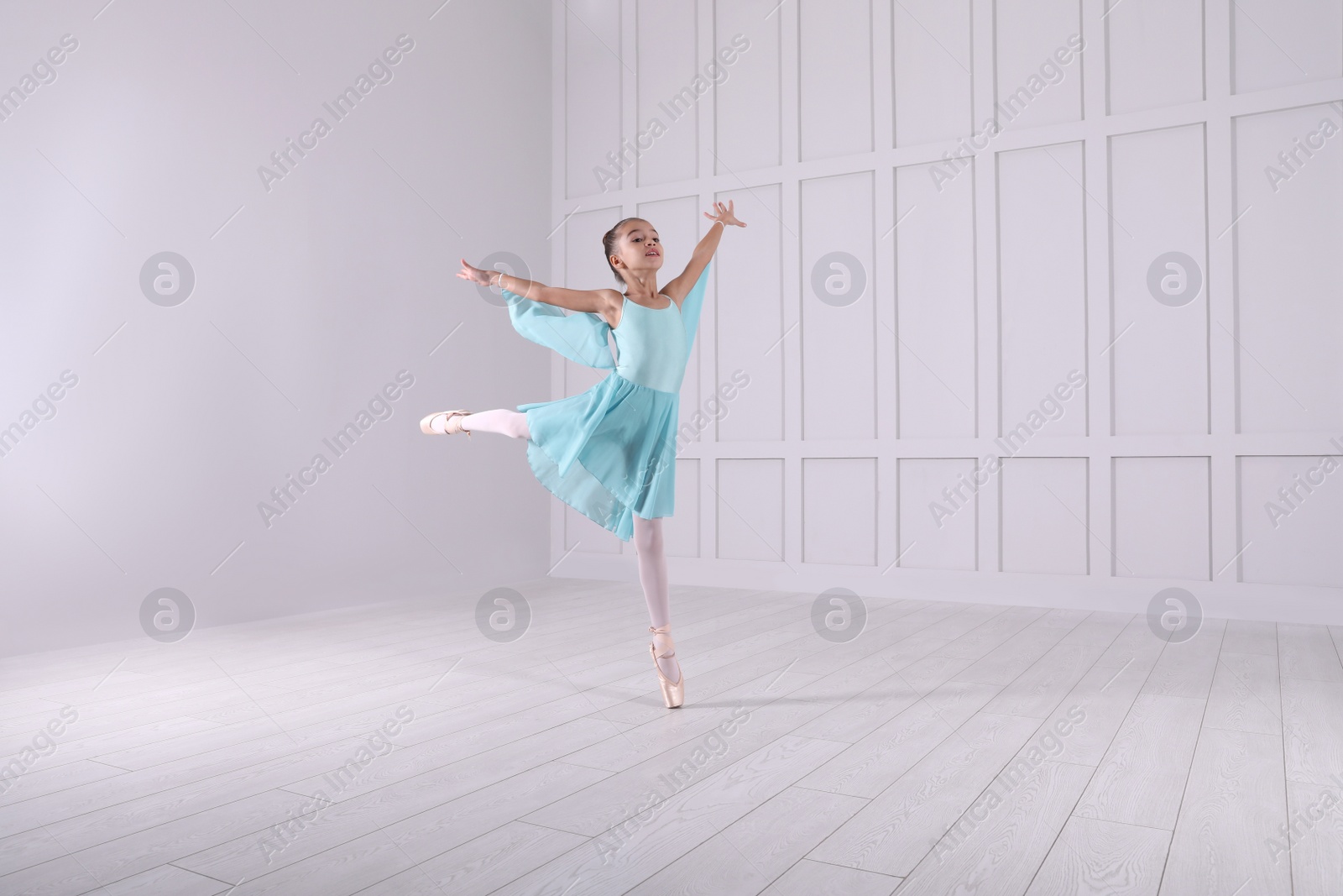 Photo of Beautifully dressed little ballerina dancing in studio. Space for text 