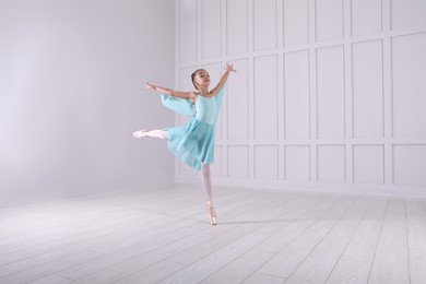 Beautifully dressed little ballerina dancing in studio. Space for text 