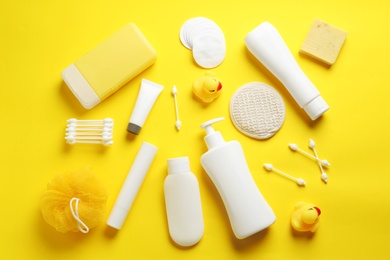 Photo of Flat lay composition with baby cosmetic products on yellow background