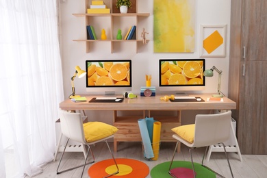 Modern workplace with large desk and computers in room. Stylish interior