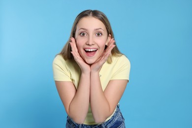 Photo of Portrait of surprised teenage girl on light blue background