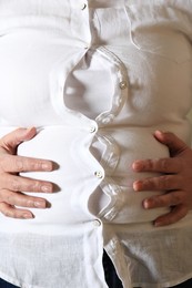 Photo of Closeup view of overweight woman in tight shirt as background