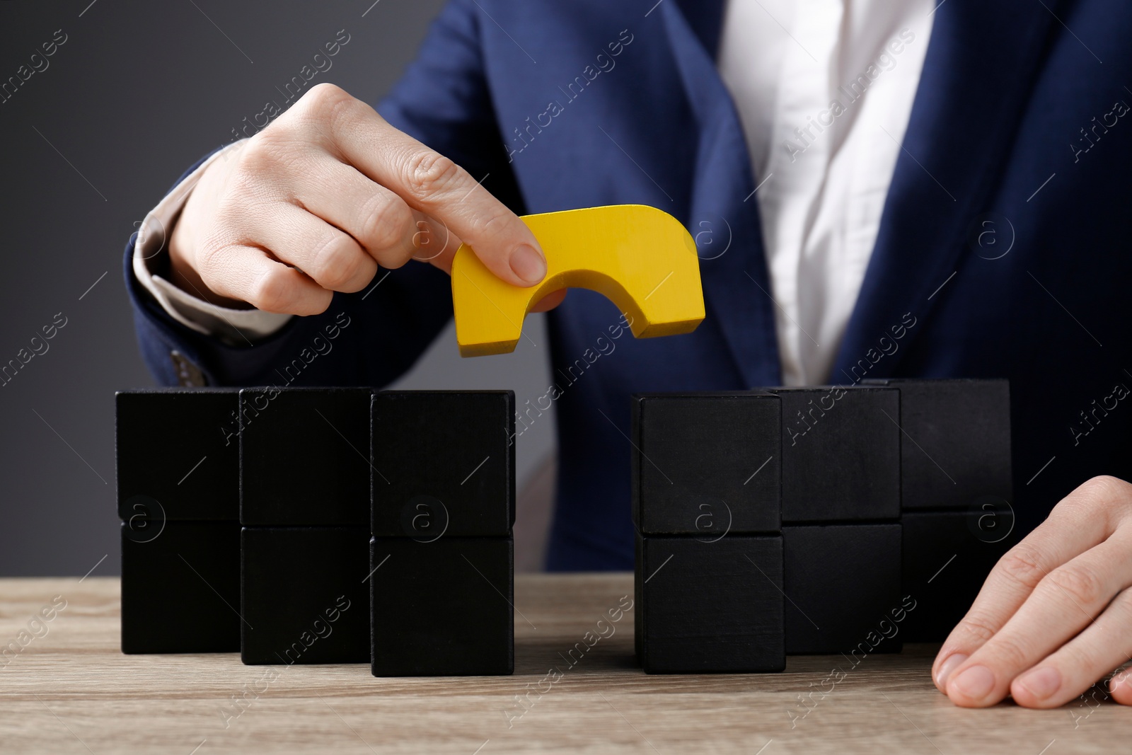 Photo of Businesswoman building bridge with colorful blocks at table, closeup. Connection, relationships and deal concept