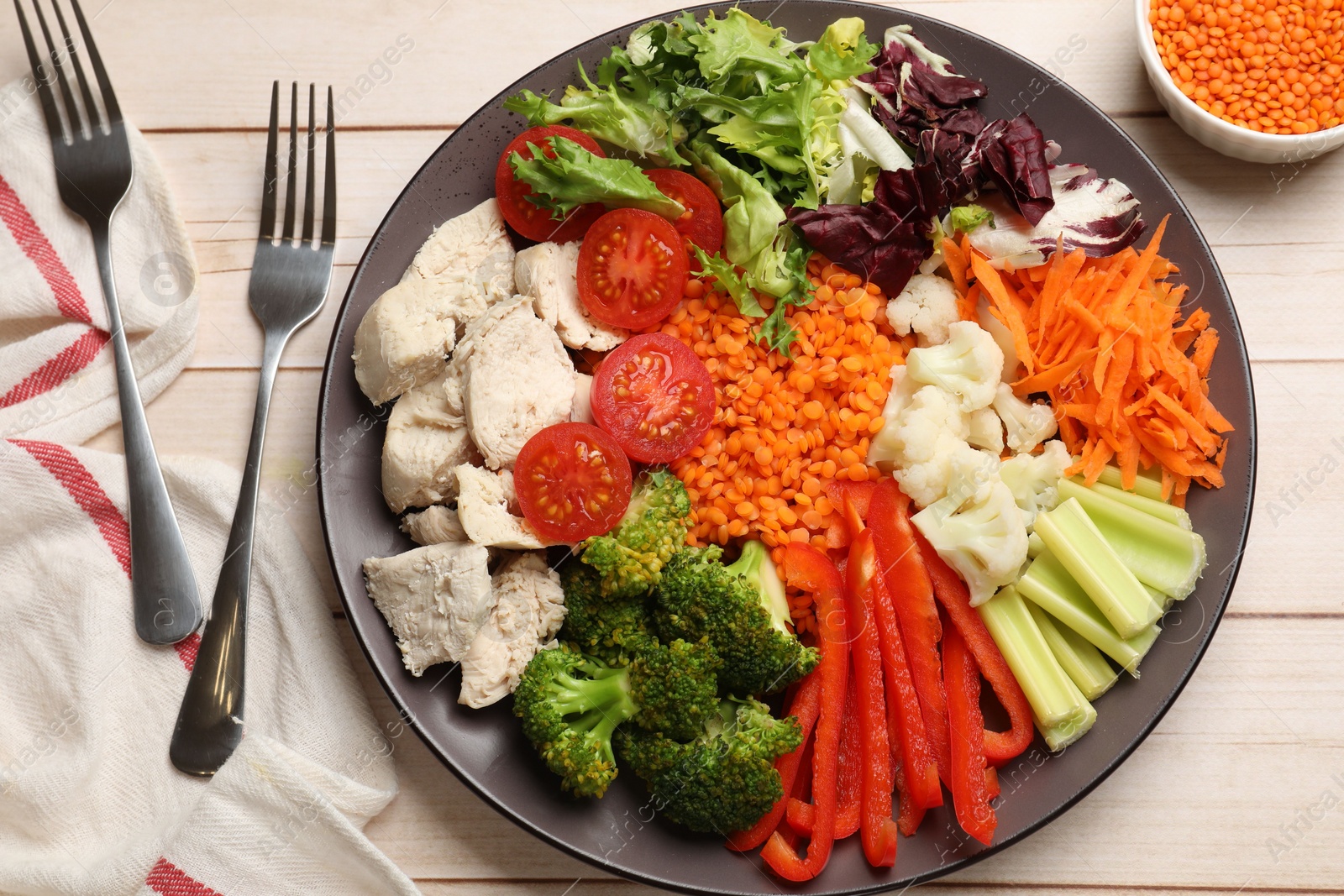 Photo of Balanced diet and healthy foods. Plate with different delicious products served on light wooden table, top view