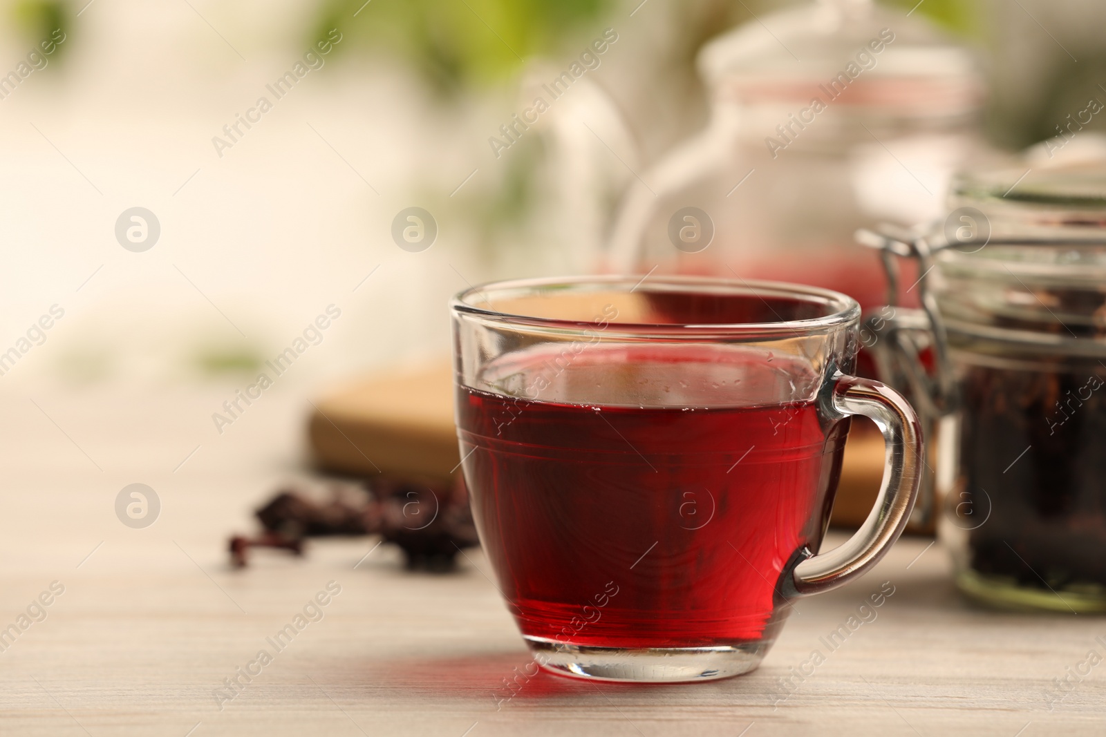 Photo of Delicious hibiscus tea on white wooden table, space for text