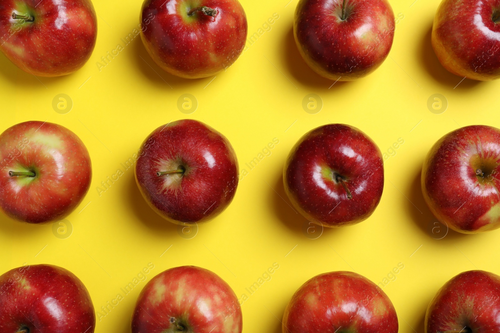 Photo of Tasty red apples on yellow background, flat lay