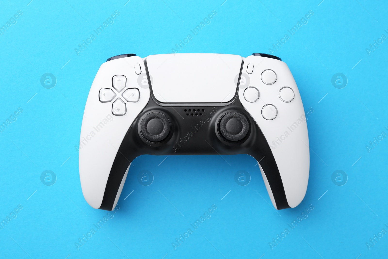 Photo of Wireless game controller on light blue background, top view