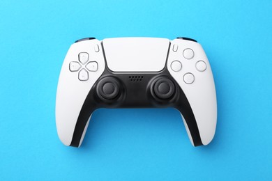 Photo of Wireless game controller on light blue background, top view