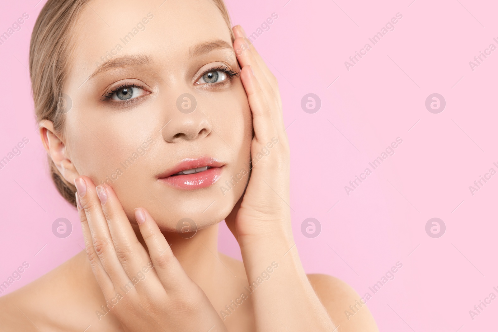 Photo of Portrait of young woman with beautiful face on pink background, closeup. Space for text