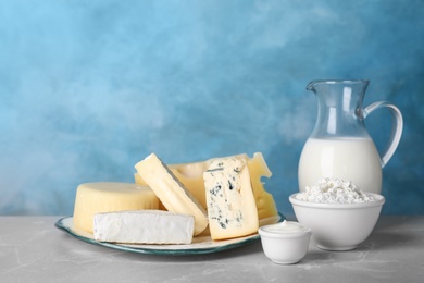 Photo of Fresh dairy products on table against color background