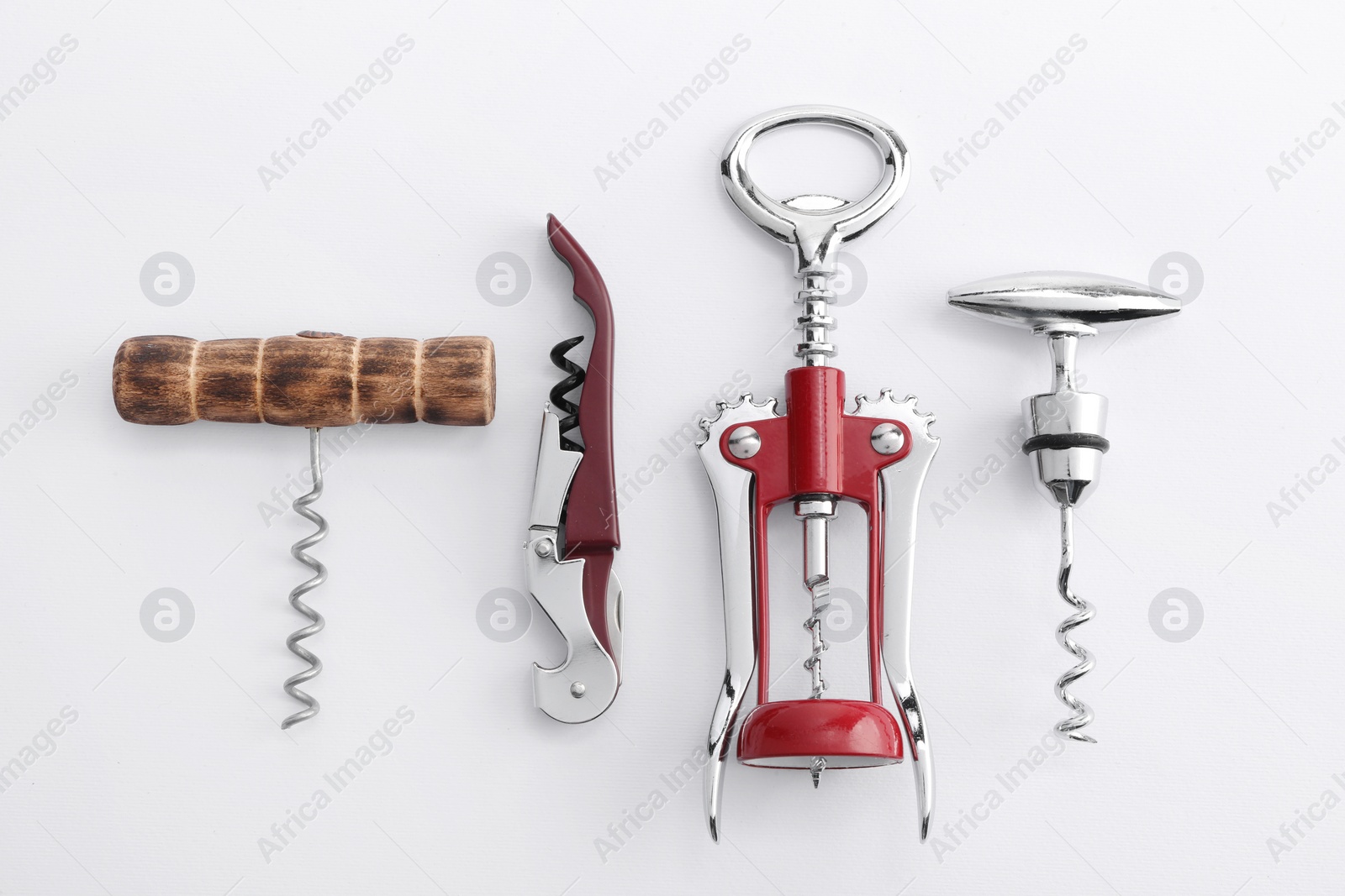 Photo of Different corkscrews on white background, flat lay