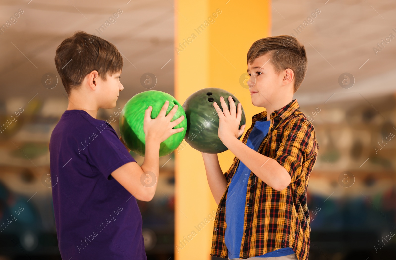 Photo of Happy boys with balls in bowling club