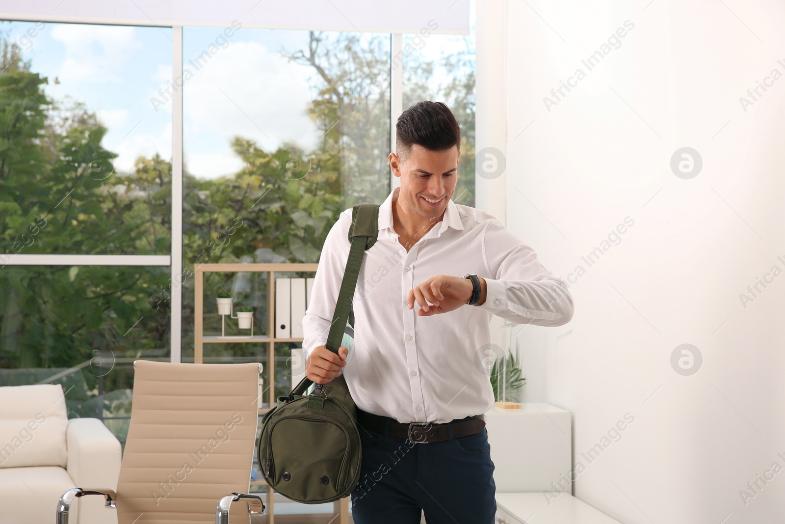 Photo of Handsome businessman with sports bag in office