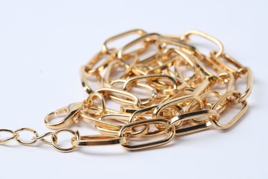 Photo of One metal chain on white background, closeup. Luxury jewelry