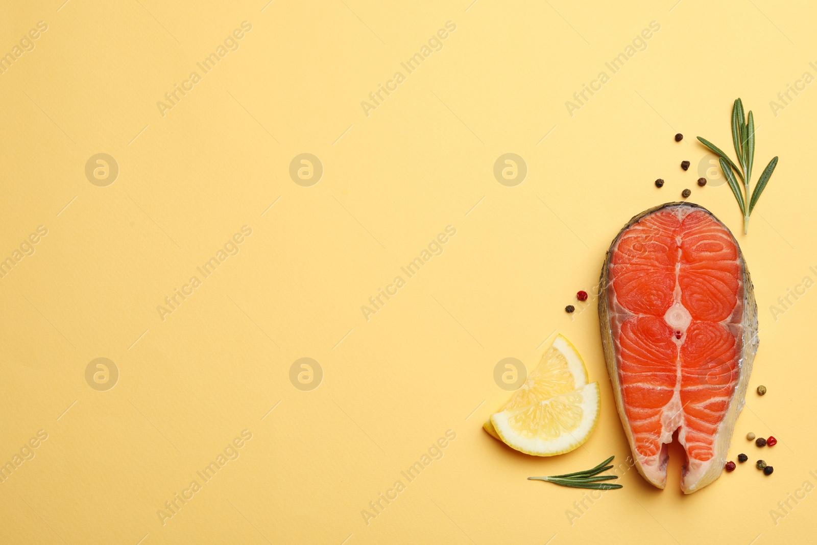 Photo of Flat lay composition with salmon steak on yellow background. Space for text