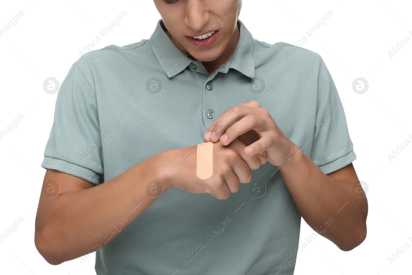 Photo of Man putting sticking plaster onto hand on white background, closeup